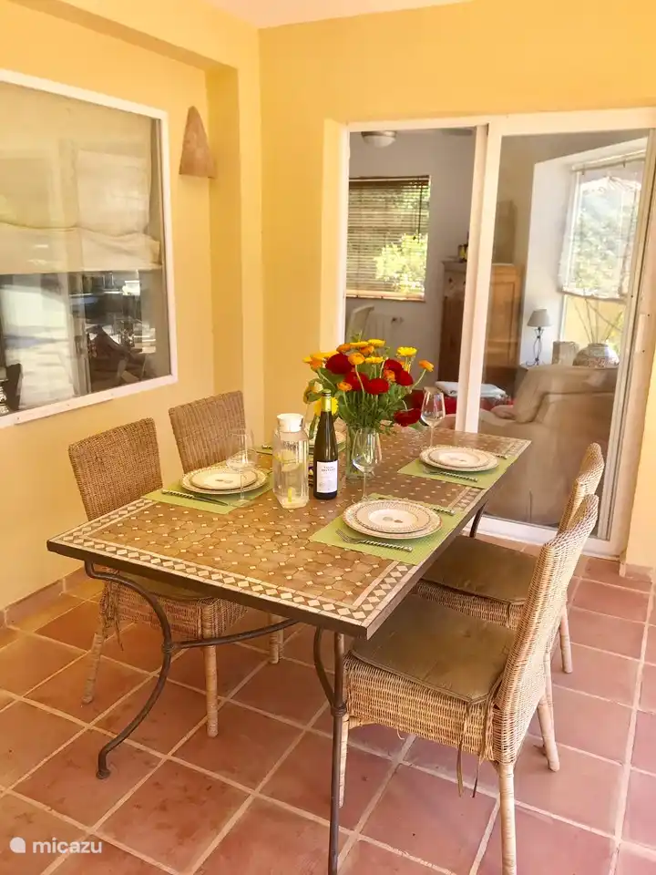 Terrasse couverte avec table à manger.