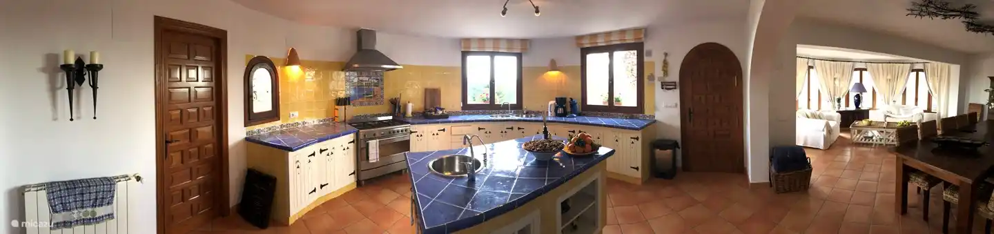 Cuisine spacieuse et ensoleillée avec cuisinière Smeg, îlot de cuisson et plusieurs points d'eau. Dans l'îlot de cuisine, il y a un robinet avec de l'eau purifiée provenant de notre propre station d'épuration.