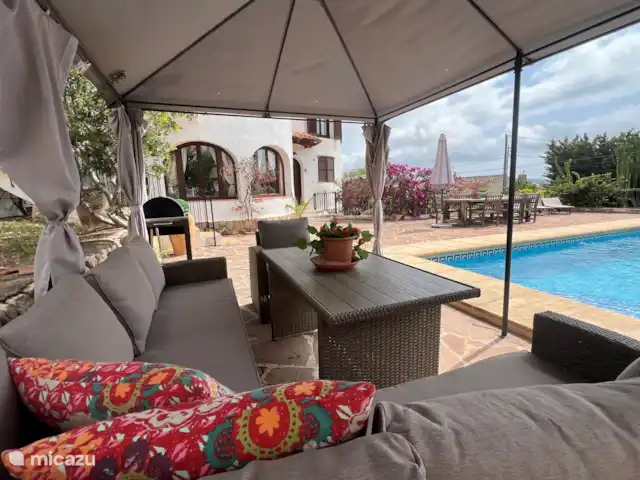 La Casa del Sol huren in Spanje, Costa Blanca, Moraira - villa zomeropstelling met loungeset achter het zwembad en 8 persoons eettafel op het terras