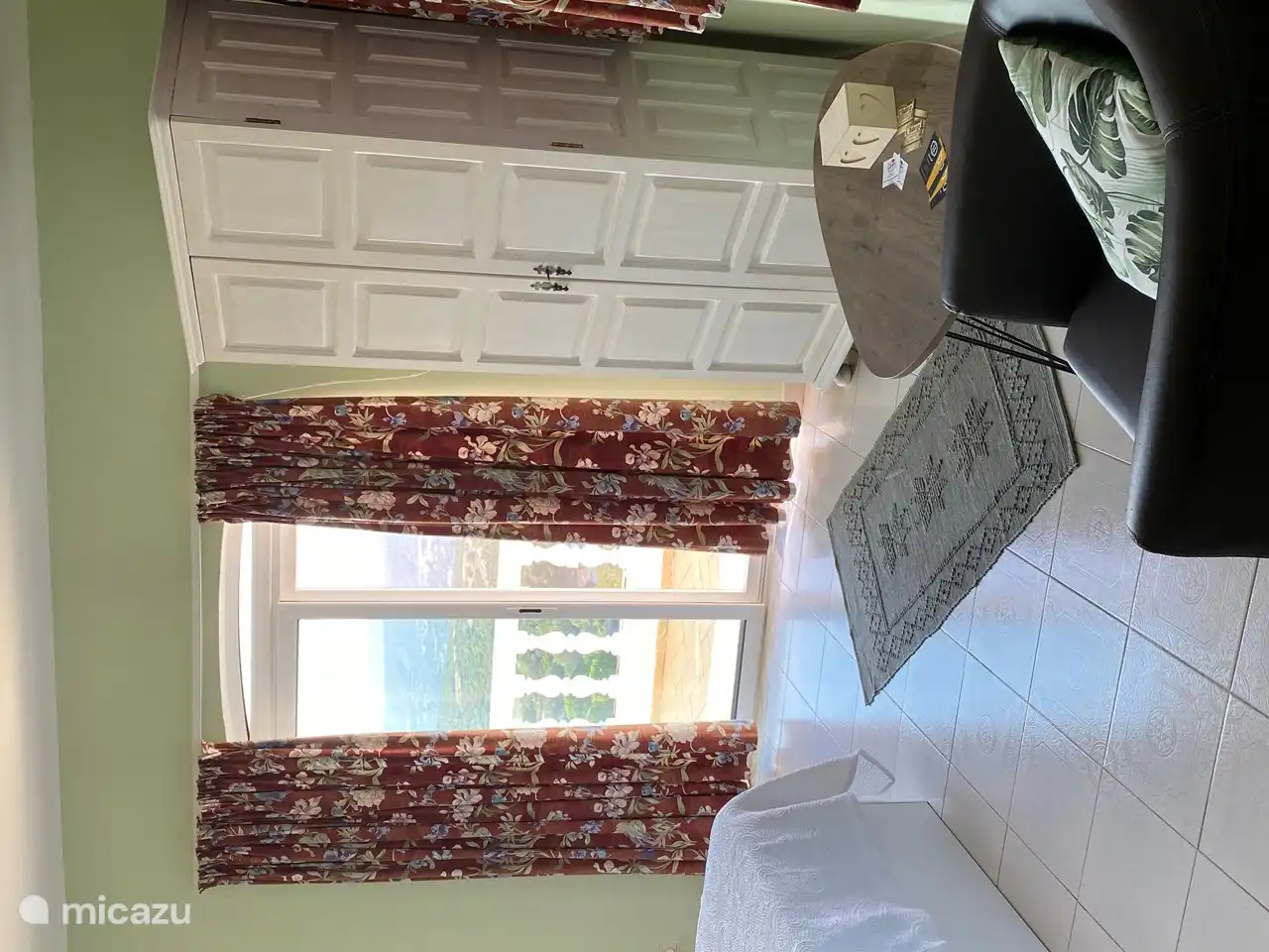 segundo dormitorio con vista a la terraza y mesa de lectura con sillón relax