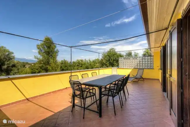 Hay una amplia terraza en frente del apartamento, con un toldo sobre la gran mesa de comedor de piedra natural.