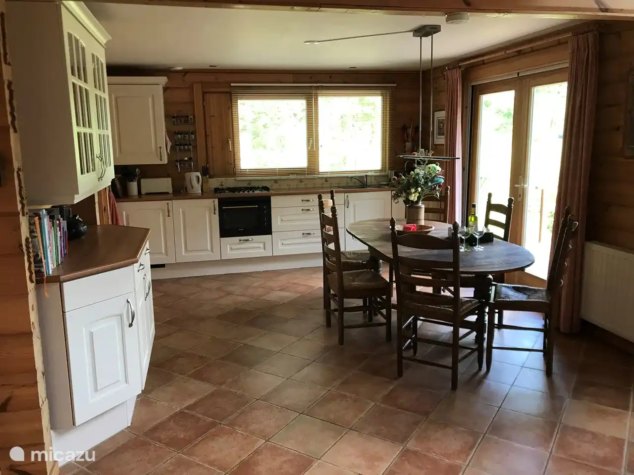 Offene Küche mit allen Einrichtungen und Esstisch.