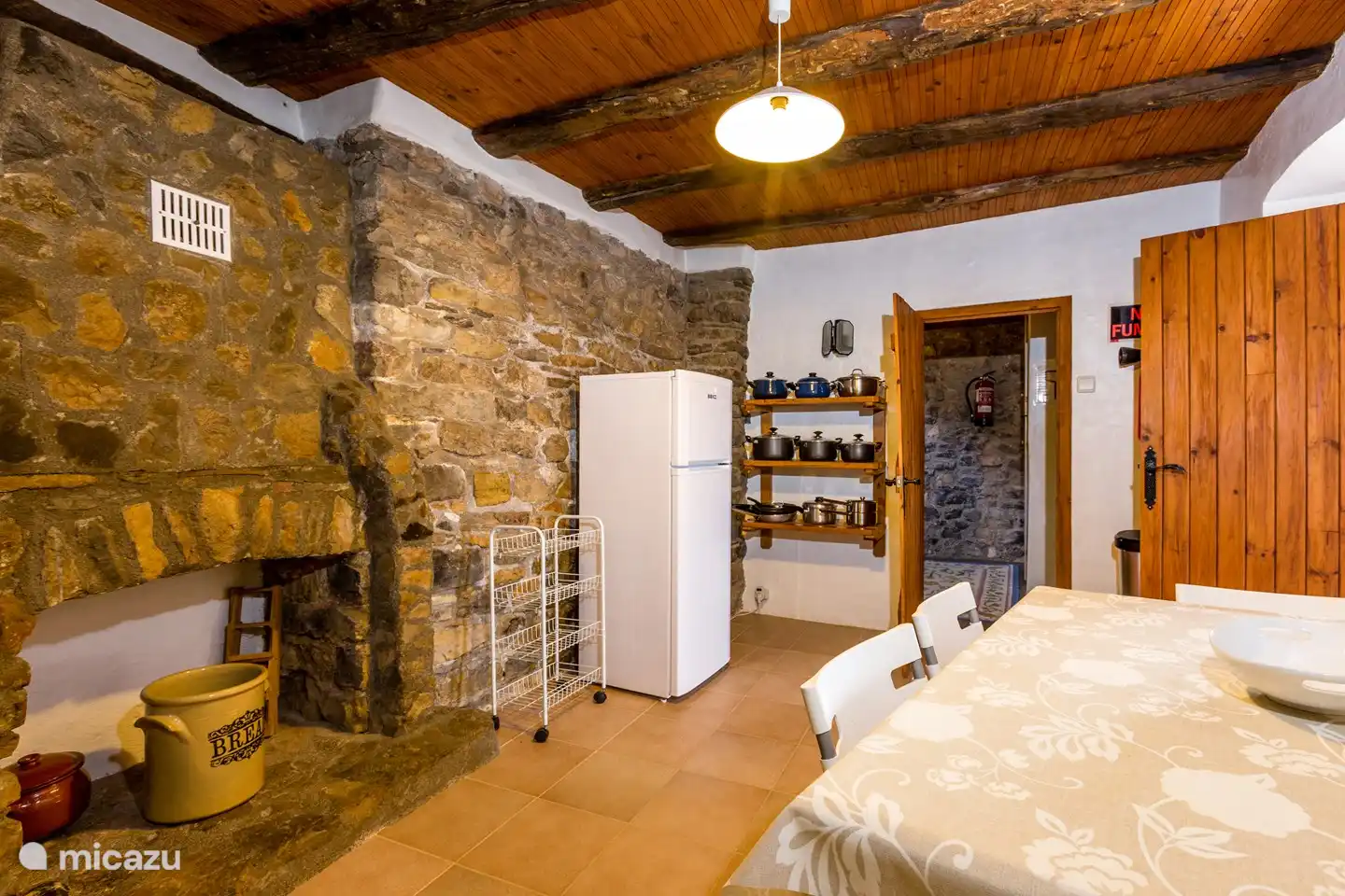 Es gibt einen großen Kühlschrank und viele Pfannen.