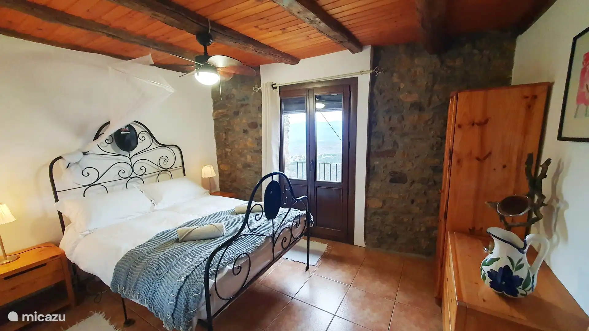 Schlafzimmer 1, mit französischem Balkon und Deckenventilator.