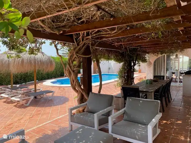 Heureux dans le salon lounge, sous la végétation de jasmin, surtout pendant les mois chauds.