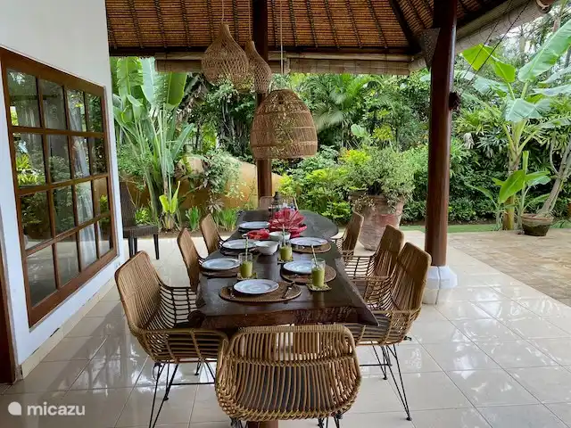Terraza cubierta con vistas a la piscina y al mar.