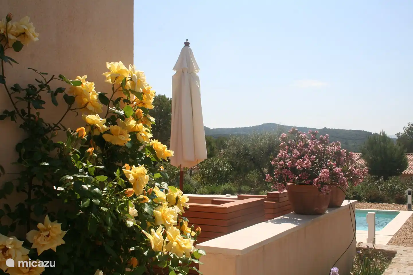 Blick auf Garten, Pool und Umgebung von der Seite des Hauses.