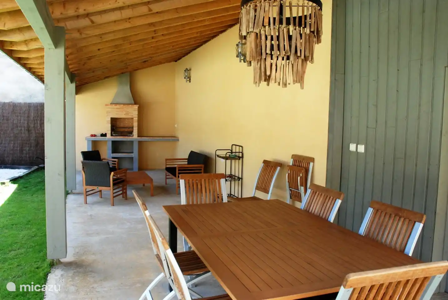 Ein großer Esstisch und Grill auf der Veranda