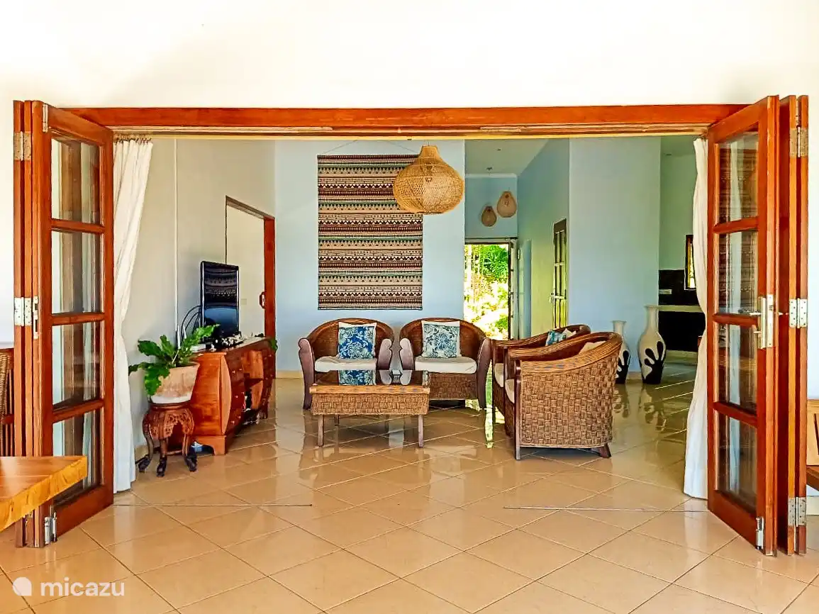 Das Wohnzimmer von der geräumigen Veranda mit Mundharmonika-Türen für das Leben im Innen- und Außenbereich.