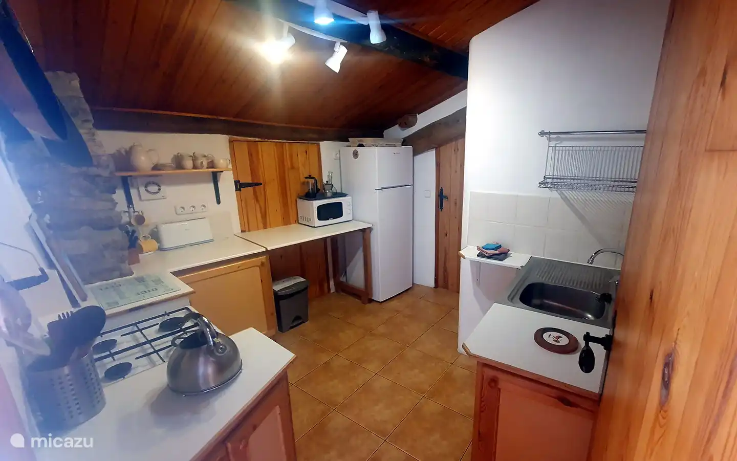 Die Küche umfasst einen geräumigen Kühlschrank mit Gefrierfach und eine Mikrowelle.