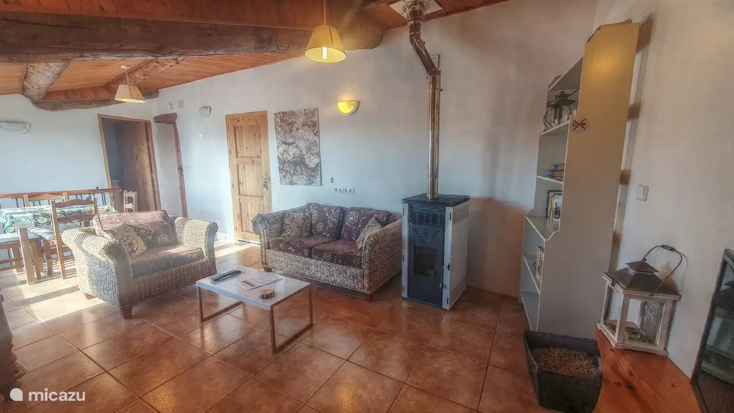 Das Wohnzimmer verfügt über einen Pelletofen und einen Fernseher.