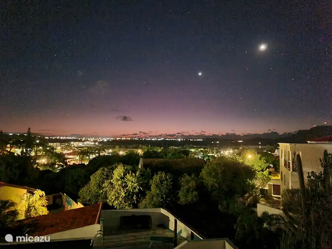 Zicht vanaf terras over Spanish Water en omgeving bij nacht 