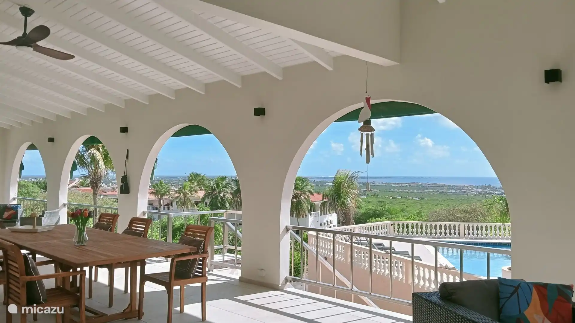 Long dining table with chairs. Above a fan with built-in lamp.