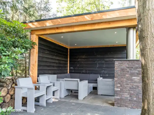 De Bosrand 55 huren in Nederland, Overijssel, Denekamp - vakantiehuis Lounge zitje bestaande uit steigerhouten planken onder overkapping.