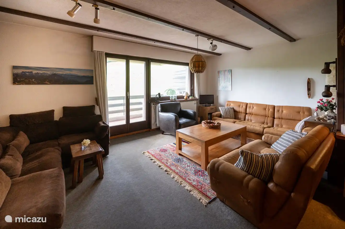 Woonkamer met openslaande deuren naar terrasbalkon.