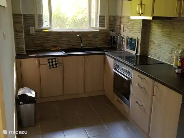 Location de Vacances Grèce, Attique orientale, Nea Makri, appartement - Aphrodite cuisine spacieuse, avec vue sur le balcon arrière et la cour arrière.