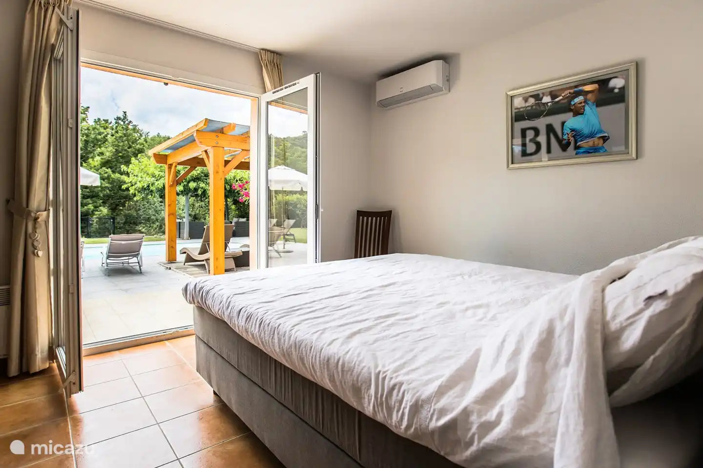 De mooiste slaapkamer beneden: door de openslaande deuren kijkt u zo op het dorpje Sampzon en loopt u als u wilt direct naar het zwembad. Heerlijk!