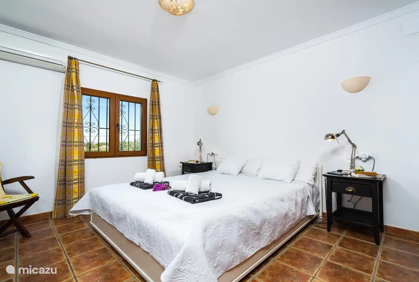 Ein geräumiges Schlafzimmer mit Doppelbett und Klimaanlage.