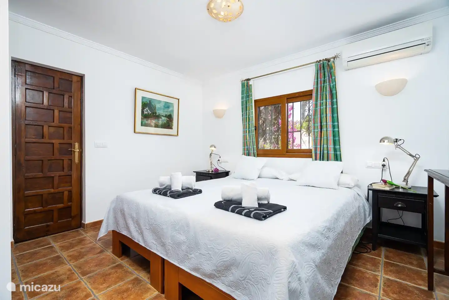 Ein geräumiges Schlafzimmer mit Doppelbett und Klimaanlage.