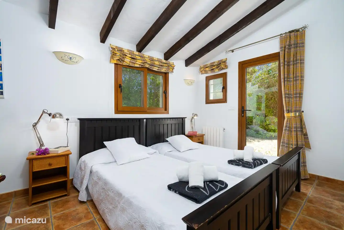 Ein geräumiges Schlafzimmer mit zwei Einzelbetten und Klimaanlage.