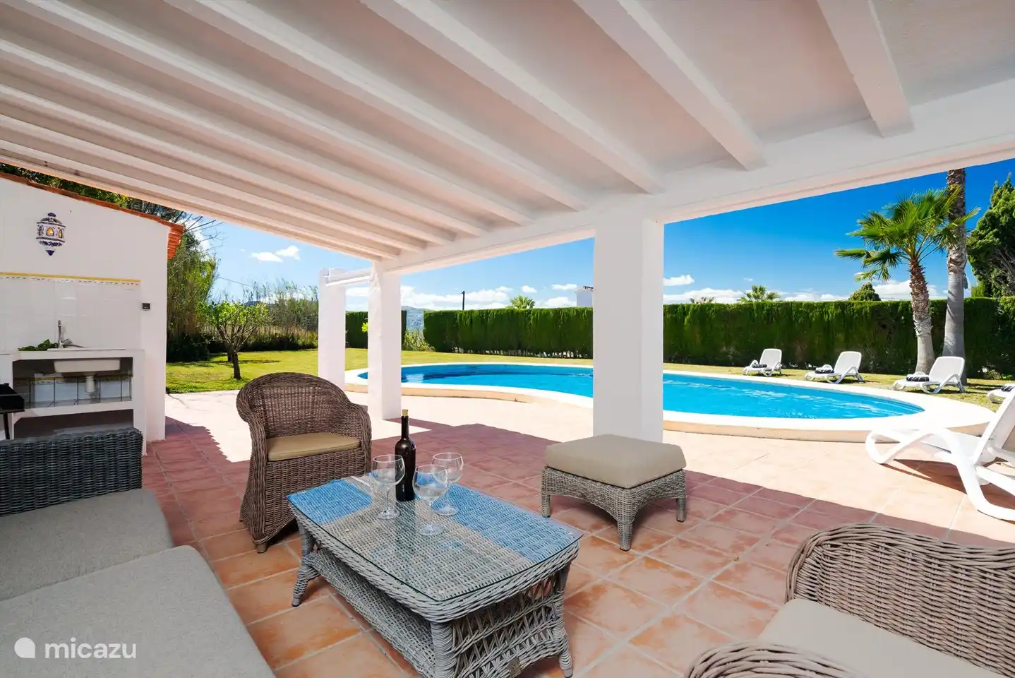 Die Lounge am Pool mit vielen Sitzmöglichkeiten und Blick in den wunderschönen Garten.