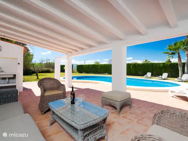 Casa Danesa | Espagne, Costa Blanca, Jávea - villa Le salon au bord de la piscine avec de nombreuses options de sièges et une vue sur le magnifique jardin.