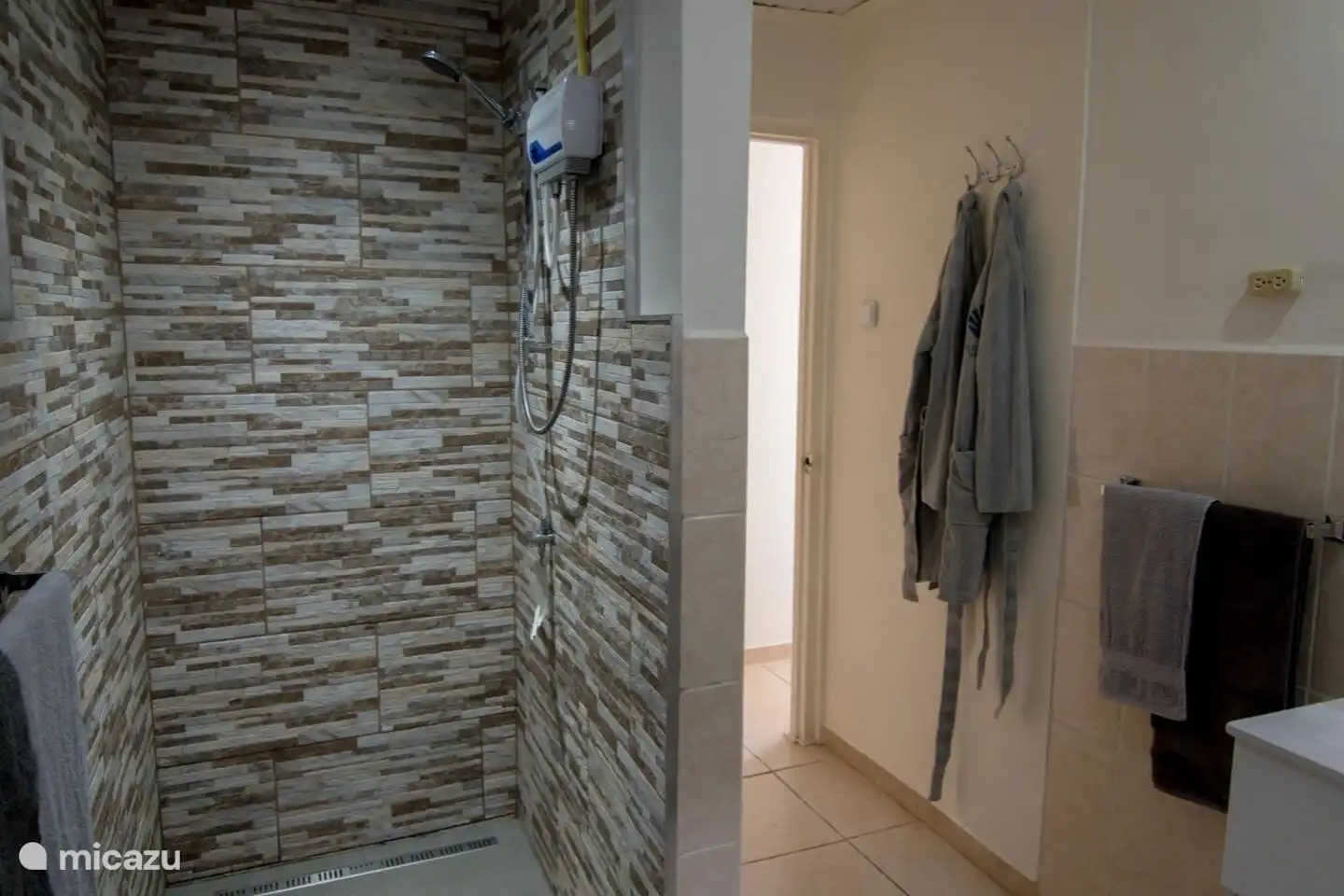 Fijne badkamer met wastafel, toilet, inloopdouche met warm water (niet gebruikelijk op Aruba) en gratis gebruik van handdoeken