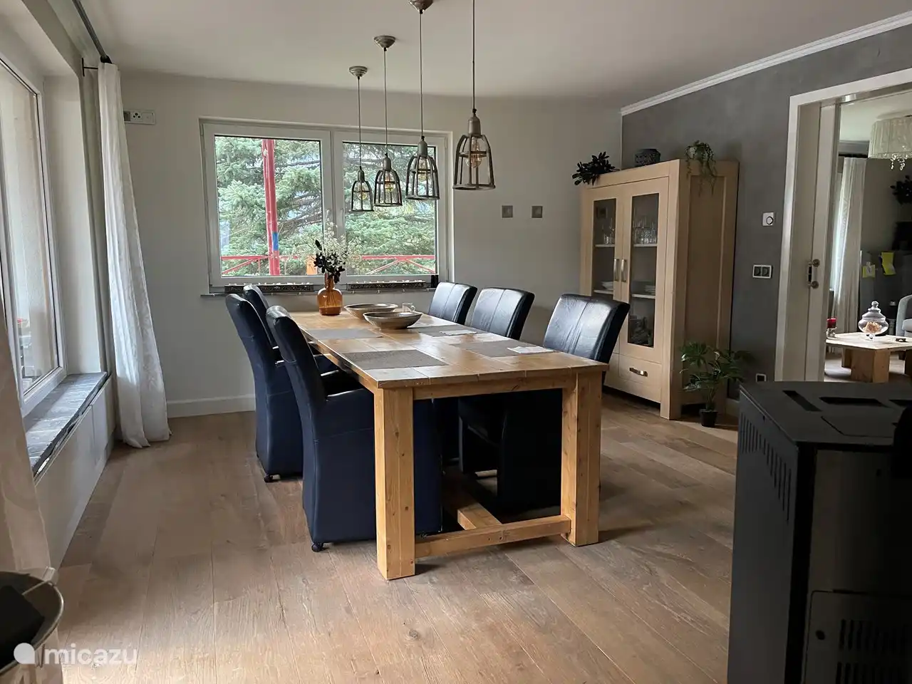 Amplia y acogedora sala comedor con vista al valle y las montañas. Una estufa de palés para mayor comodidad y calidez. La amplia mesa para 6 personas con sillas a juego con reposabrazos y un televisor adicional completan el cuadro.