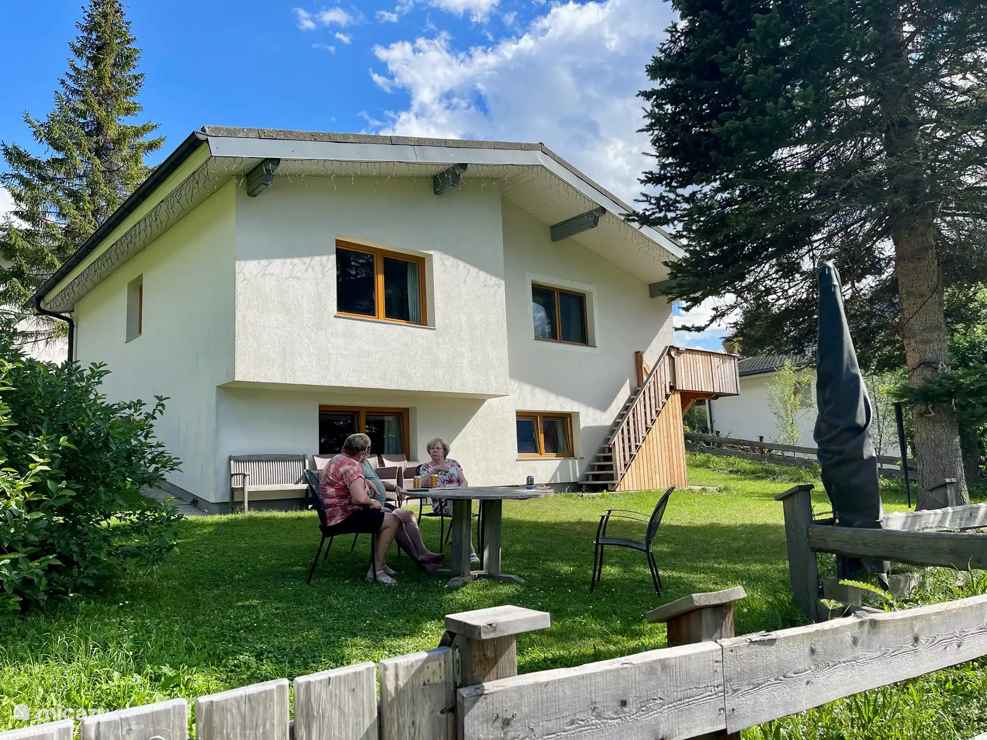 Parte trasera de la casa con amplia zona para tomar el sol en las hermosas montañas