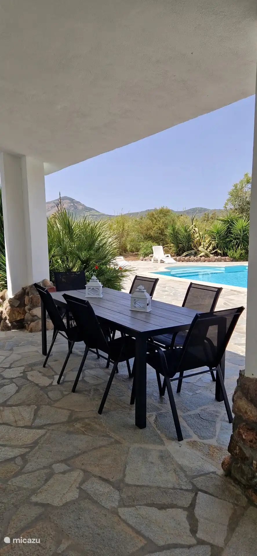 De eettafel onder de veranda bij het zwembad