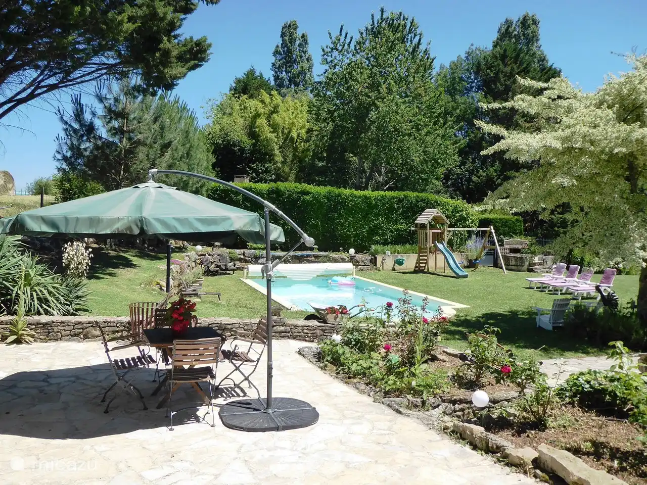 Blick auf den Garten, Sonnenliegen, Swimmingpool, Spielturm von der Terrasse