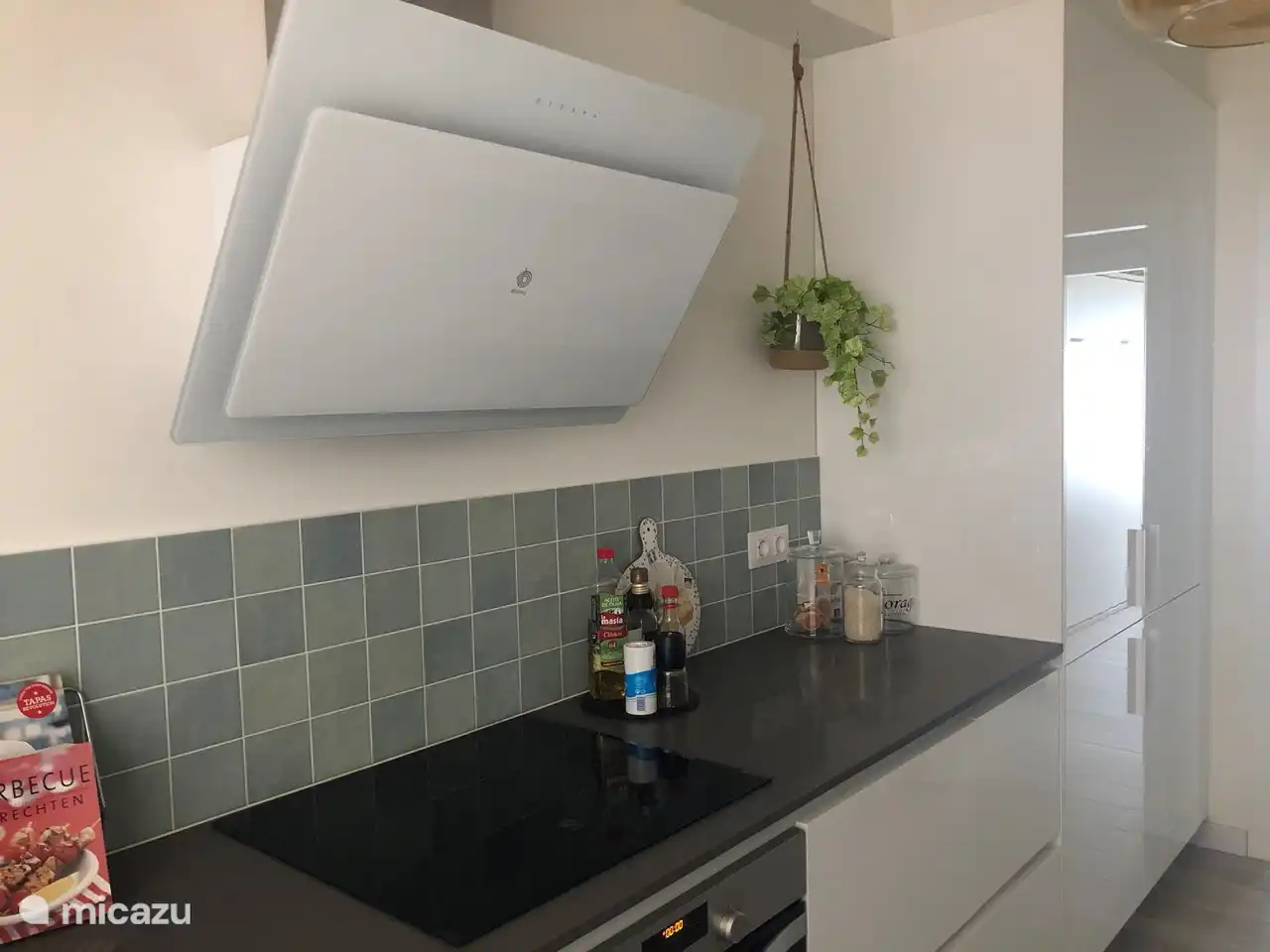 Modern kitchen with dishwasher, oven, Nespresso machine, microwave and induction hob.