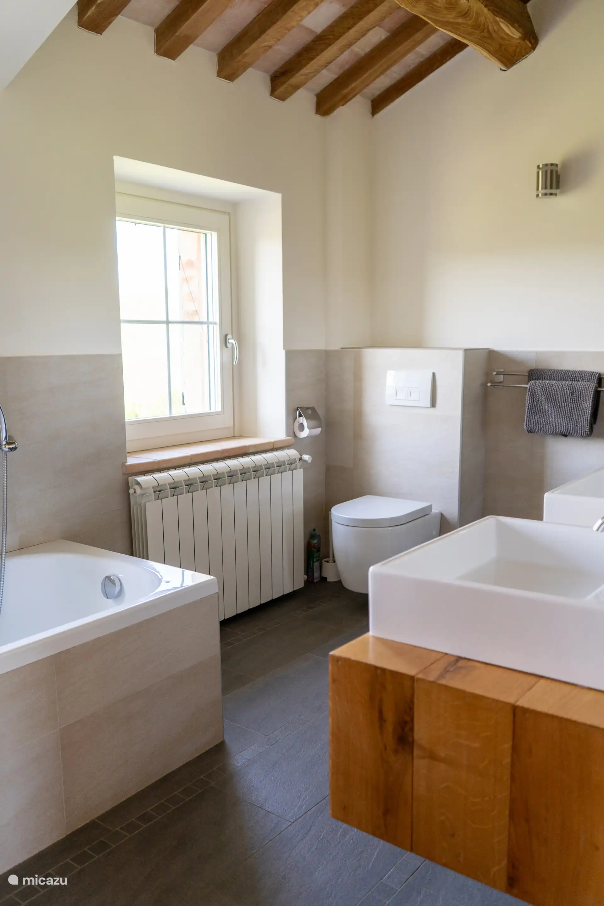 Badkamer met 2 wastafels, douche en ligbad.
