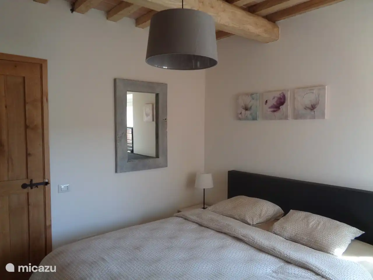 Au rez-de-chaussée se trouve également une chambre avec un lit double à sommier tapissier, deux tables de chevet et une armoire. Cette chambre dispose d’une salle de bain privative avec toilettes, lavabo et douche à l’italienne.