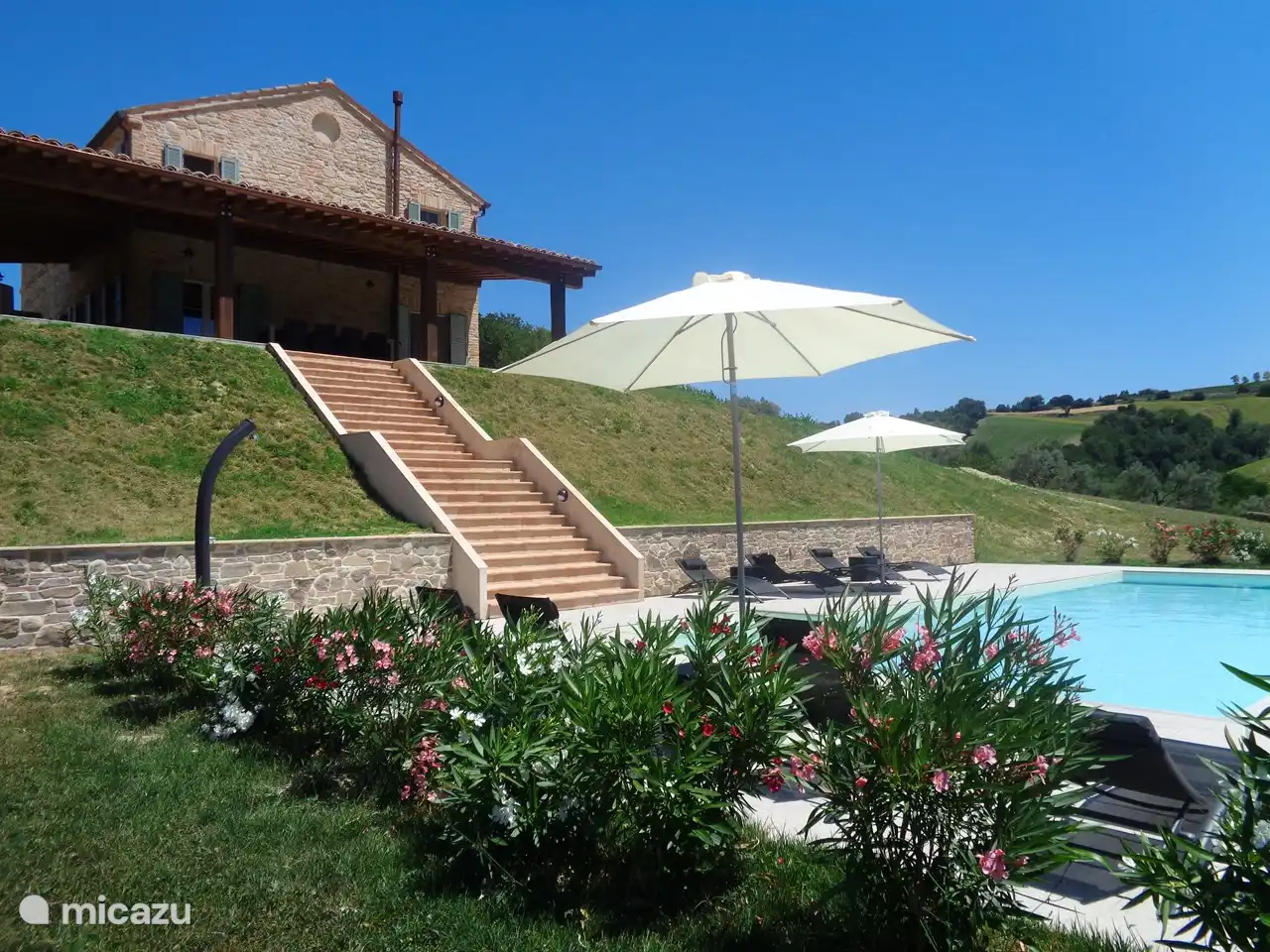 Les 8 bains de soleil avec tables et parasols assortis sont prêts à accueillir les invités.