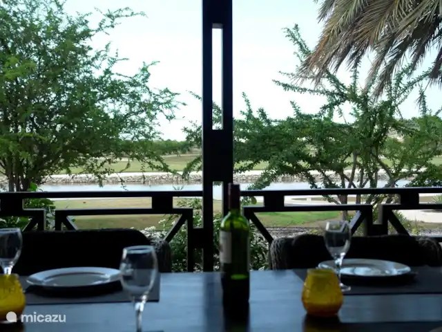 Location de Vacances Curaçao, Curaçao-Centre, Blue Bay, villa - Villa BlueBay à 50m de la plage des palmiers Vue depuis votre table à manger sur un lac avec des flamants roses et un terrain de golf