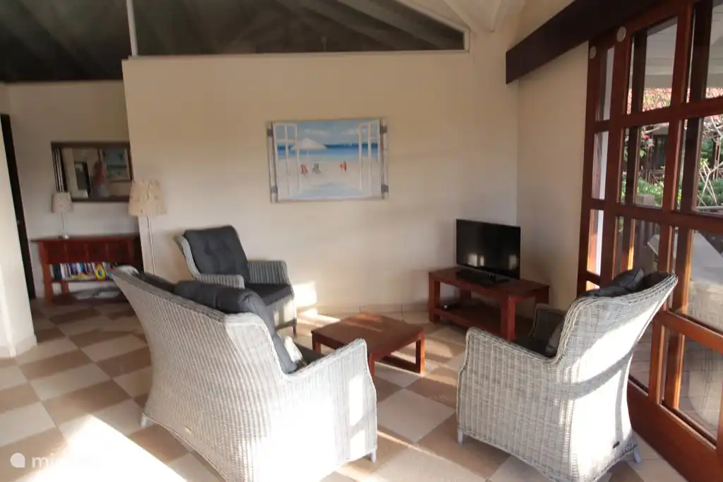 Living room with modern flat screen TV, high ceiling.