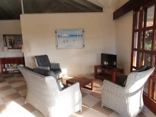 Location de Vacances Curaçao, Curaçao-Centre, Blue Bay, villa - Villa BlueBay à 50m de la plage des palmiers Séjour avec TV écran plat moderne, belle hauteur sous plafond.