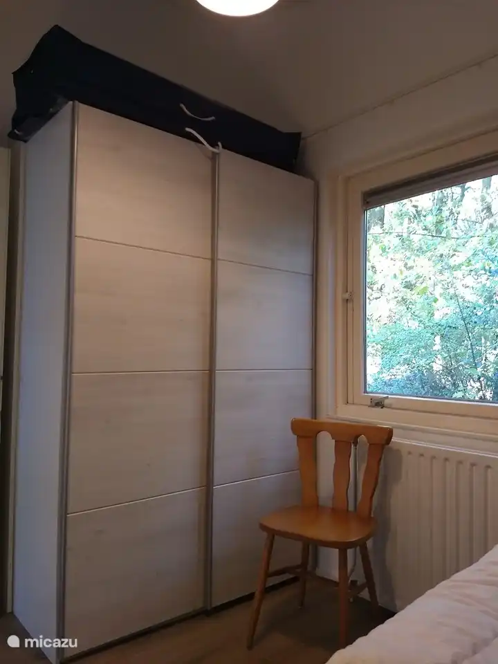 Waschmaschine und Trockner im Schrank. Auf dem Schrank befinden sich Sitzkissen für draußen auf der Terrasse.