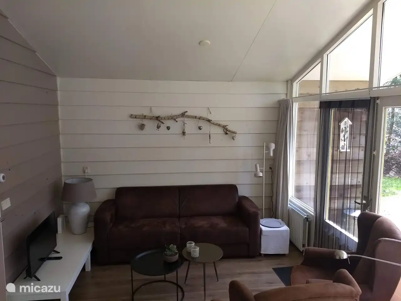 Wohnzimmer mit einem 3-Sitzer-Sofa, 2 separaten Stühlen, Tischen und einem Fernseher (inkl. Radio)