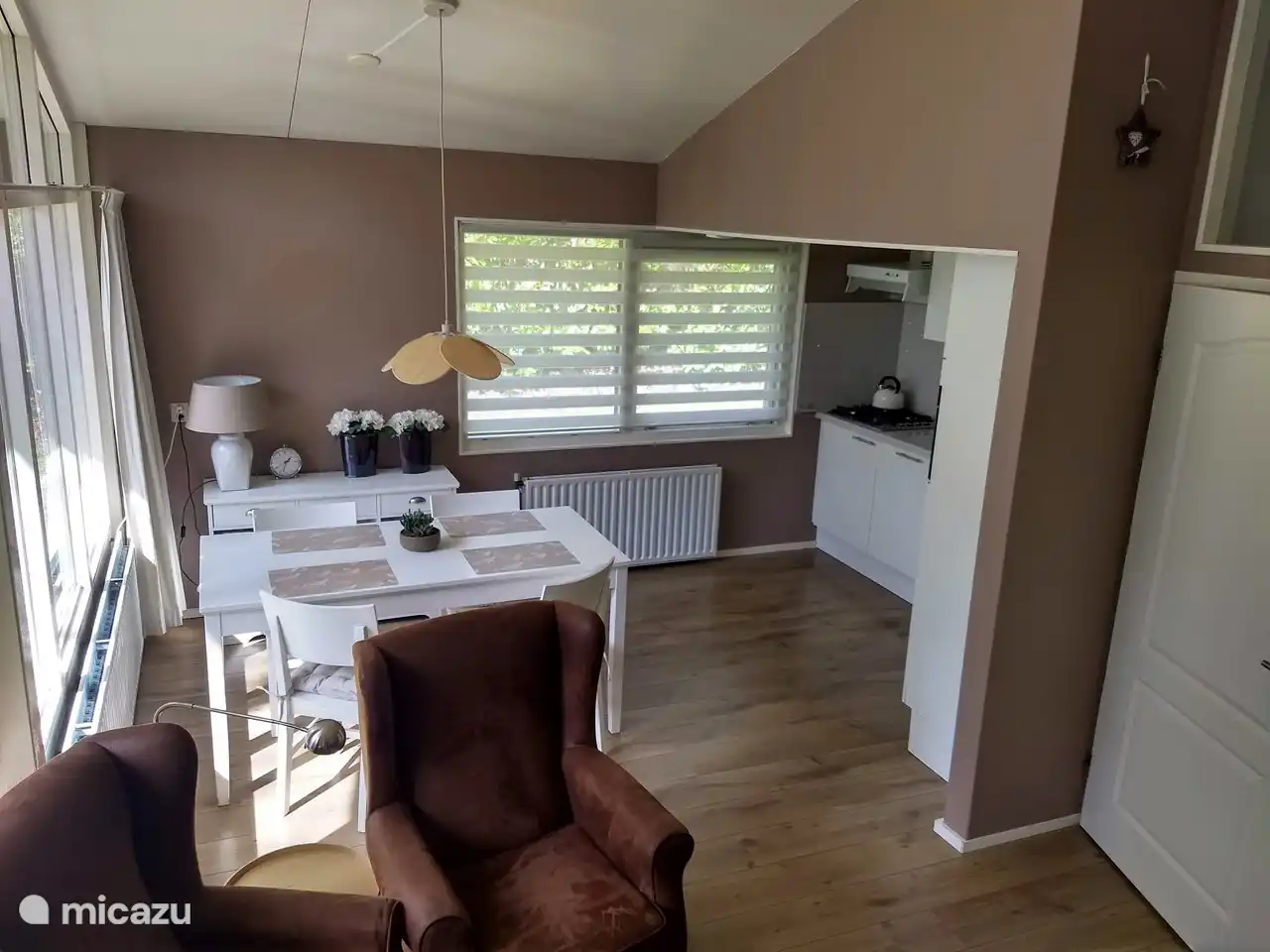 Esstisch und Küche. Die Küche ist mit einer Kombination aus Mikrowelle und Geschirrspüler ausgestattet.