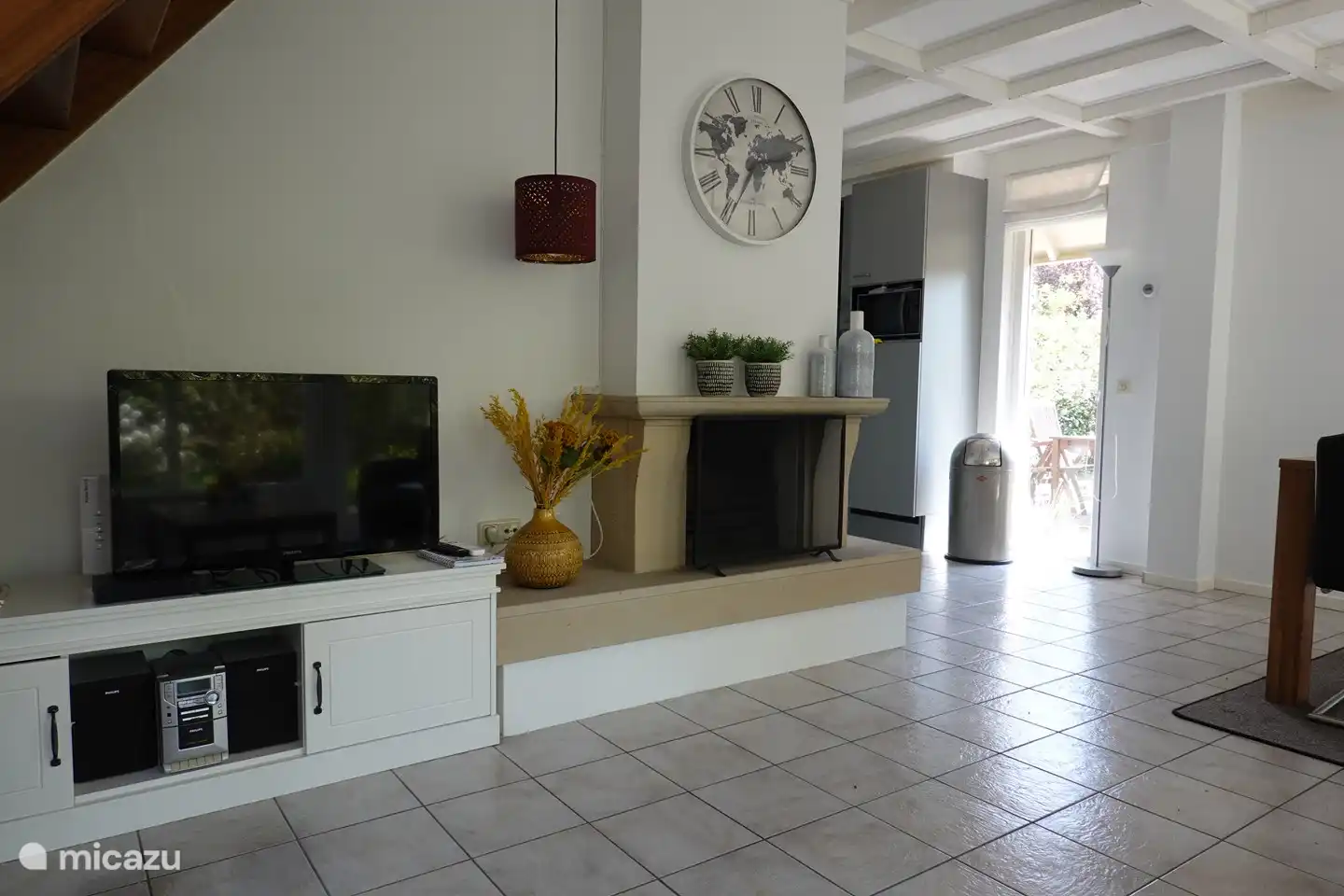 Das große Wohnzimmer verfügt über einen gemütlichen Kamin und einen Fernseher.