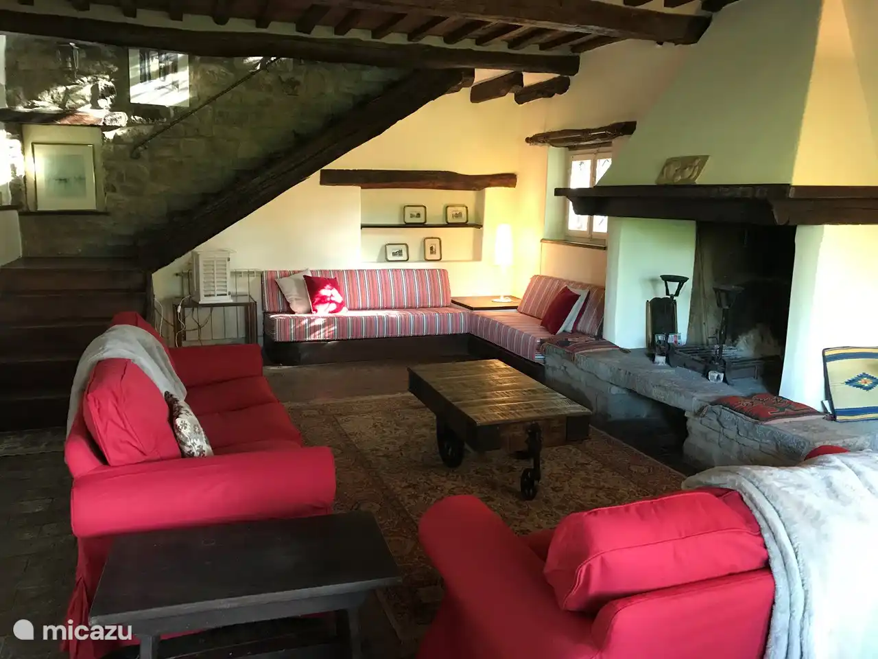 Een gezellige ruime woonkamer met comfortabele banken en een karakteristieke openhaard