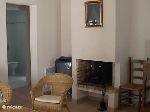 Maison Lavande | France, Vendée, La Tranche-sur-Mer - maison de vacances .Vue de la cuisine sur le coin salon. Le passage à côté de la cheminée mène à la salle de bain et aux chambres.