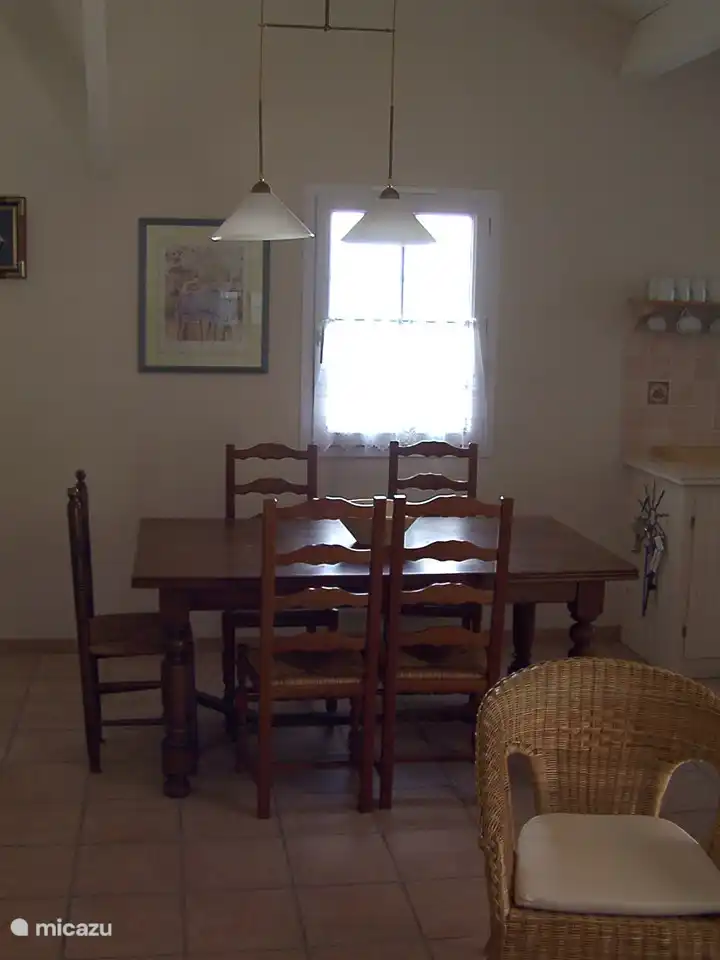 Het raam in de muur naast de eettafel zorgt voor een gezellige sfeer dankzij meer daglicht.