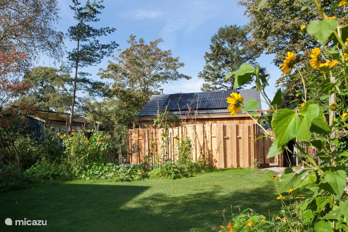 De omheining van de Ecolodge. Op het dak ziet u de zonnepanelen waarmee het huis grotendeels van energie wordt voorzien.