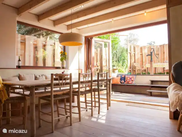 Location de Vacances Pays-Bas, Hollande du Nord, Schoorl, maison de vacances - Ecole Ecolodge de Parel Grande table à manger avec 8 places. Une chaise haute est également fournie. Vous pouvez également vous asseoir à l'extérieur dans la partie abaissée.