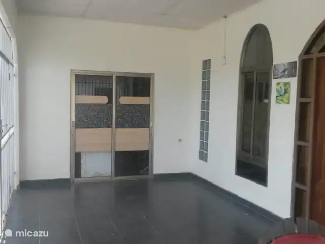 Woning:  VillaParK  -  INDIRA huren in Suriname, Paramaribo, Paramaribo - vakantiehuis Het terras met zicht op de inpandige garage t.b.v. van 2 auto's.