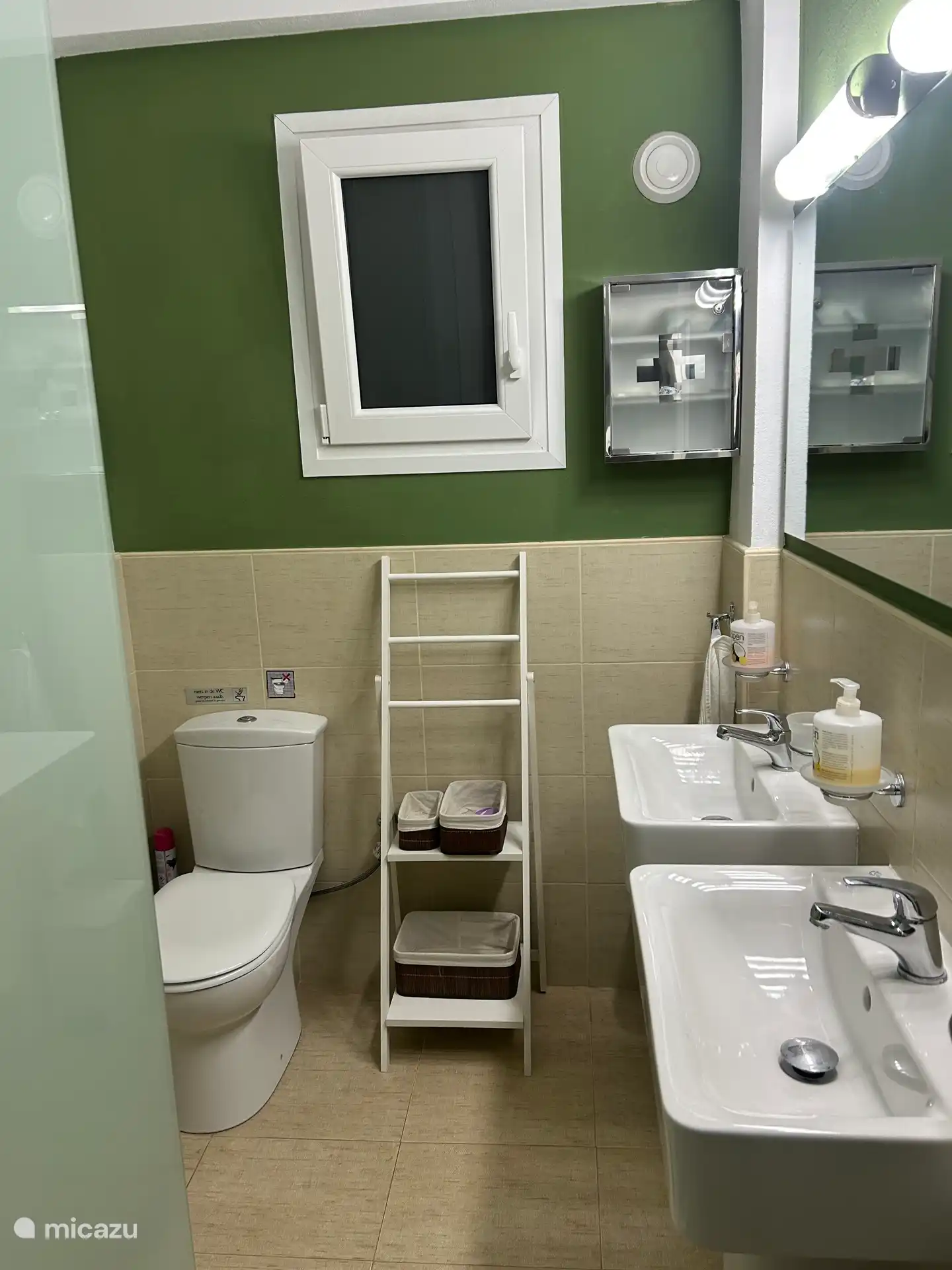 Badkamer met dubbele wastafels en inloopdouche met matglazen wand.