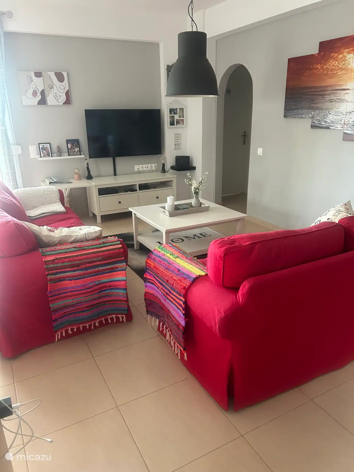 Wohnbereich mit zwei- und dreisitzigem Sofa, Couchtisch, TV-Schrank und 50 Samsung Smart TV.